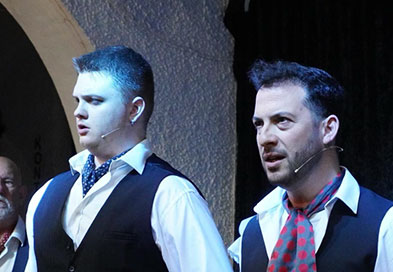 Two performers in waistcoats on stage